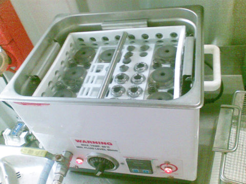 Handling basket in ultrasonic bath for cleaning nozzles